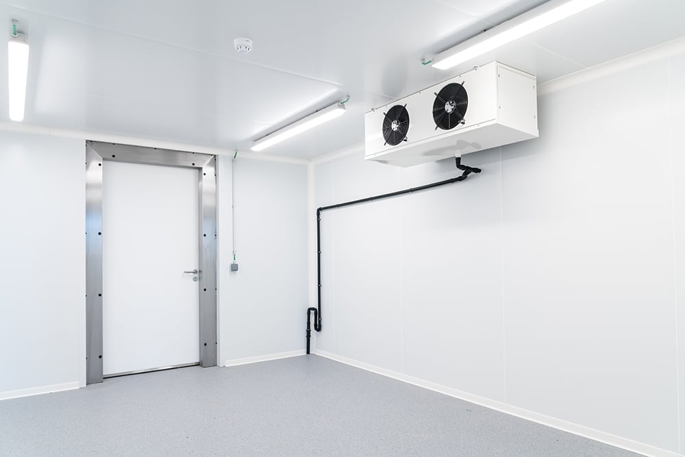 an empty industrial room refrigerator with four fans